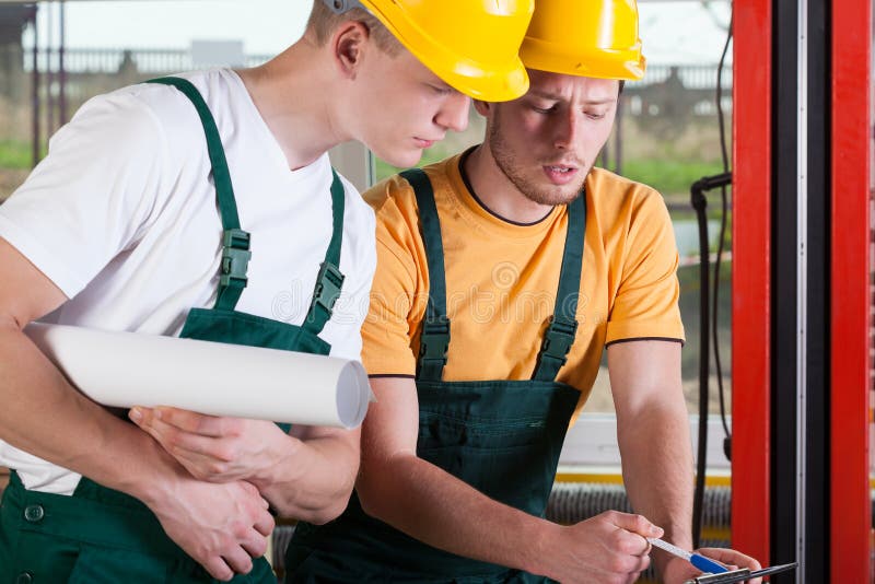 Deux ingénieurs en bâtiment souriants en tenue de chantiers tenant un plan  de travail - Photo #6299 - Jolixi