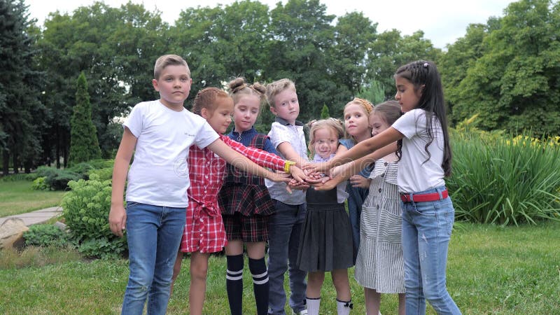 Travail d'équipe d'enfants. Un groupe d'enfants heureux ensemble main dans la main. Équipe extérieure dans le parc clips vidéos