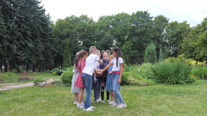 Travail d'équipe d'enfants. Un groupe d'enfants heureux ensemble main dans la main. Équipe extérieure dans le parc banque de vidéos