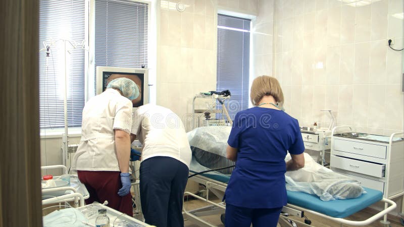 Travail d'équipe pendant le gastroendoscopy au patient dans l'hôpital photographie stock Travail d'équipe pendant le gastroendoscopy au patient dans l'hôpital photographie stock
