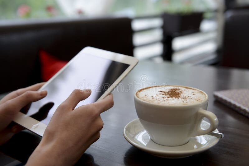 Travail dans un café avec un comprimé et une tasse de café images stock
