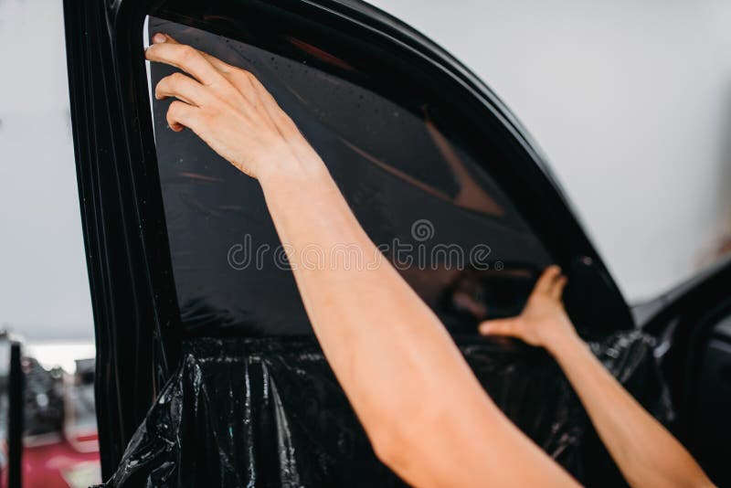 Male specialist work with car, tinting film installation process, tinted auto glass installing procedure. Male specialist work with car, tinting film installation process, tinted auto glass installing procedure