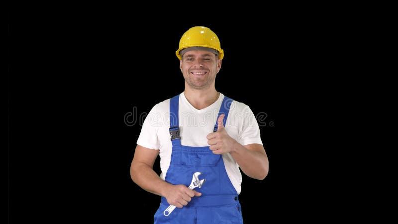 Travailleur avec le pouce d'apparence de clé et souriant à la caméra, Alpha Channel clips vidéos