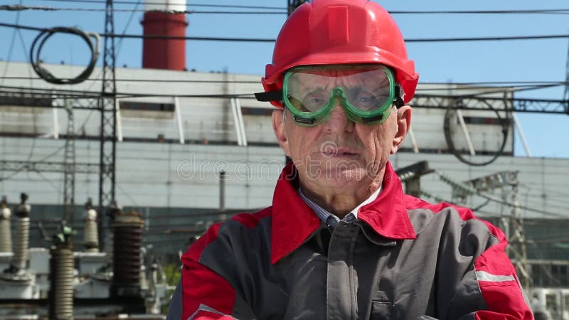 Travailleur dans le casque antichoc rouge à l'usine de puissance atomique