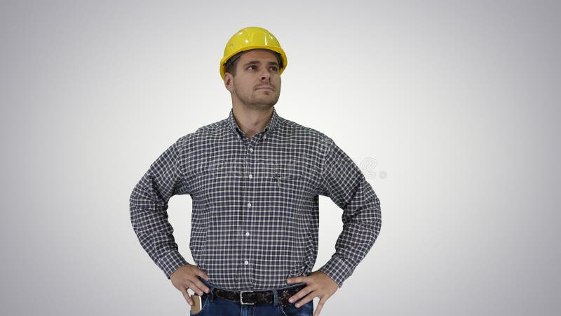 Travailleur de construction souriant dans un casque jaune regardant un objet parfait bien construit Main sur les hanches sur fond clips vidéos