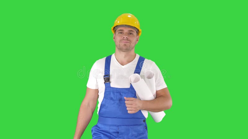 Travailleur de la construction marchant avec les croquis de mise au point et souriant à la caméra sur un écran vert, clé de chrom banque de vidéos