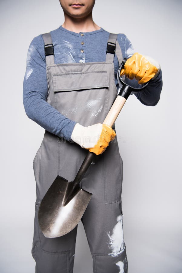 Travailleur de la construction tenant la pelle image stock