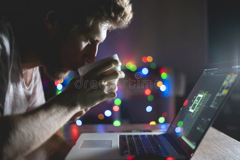 Travailleur de nuit dans le bureau se reposant à la table utilisant l'ordinateur portable et le café f de boissons images libres de droits Travailleur de nuit dans le bureau se reposant à la table utilisant l'ordinateur portable et le café f de boissons images libres de droits