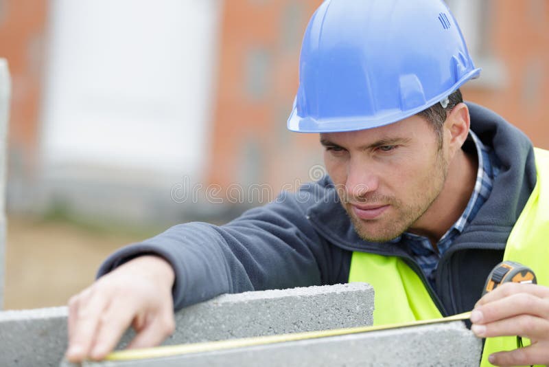 Travailleur ext?rieur employant de niveau pour ?tendre le plancher de ciment photographie stock Travailleur ext?rieur employant de niveau pour ?tendre le plancher de ciment photographie stock