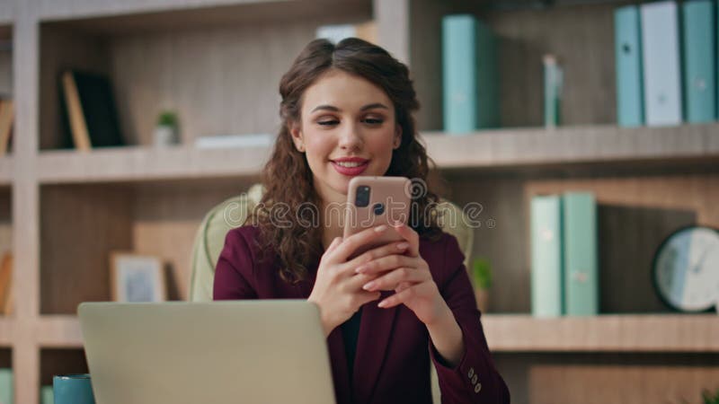 Travailleur souriant texto téléphone cellulaire au lieu de travail closeup. femme d'affaires heureuse utilisant banque de vidéos
