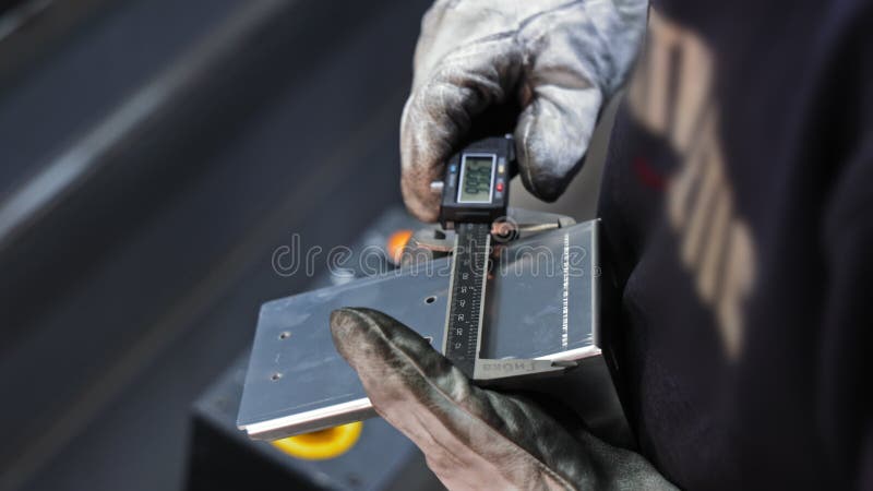 Travailleur utilisant un étrier pour mesurer le bord du support métallique avec des gants Inspection de travail métallique de préc banque de vidéos