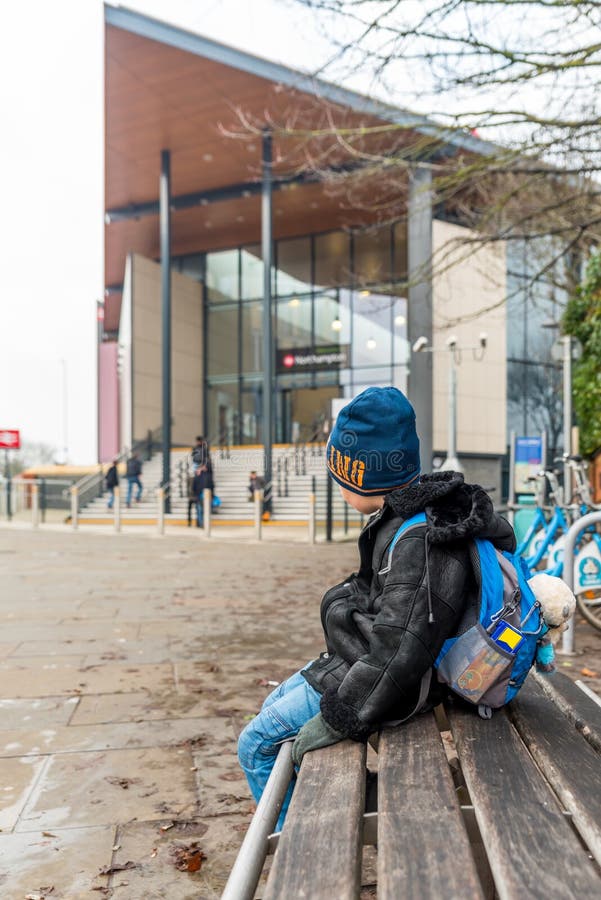 Travel concept of boy waiting at front of train station stock photo Travel concept of boy waiting at front of train station stock photo
