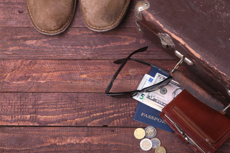 Travel concept with Vintage suitcase, sunglasses, old camera, suede boots, case for money and passport on wooden floor. Life, fashion.