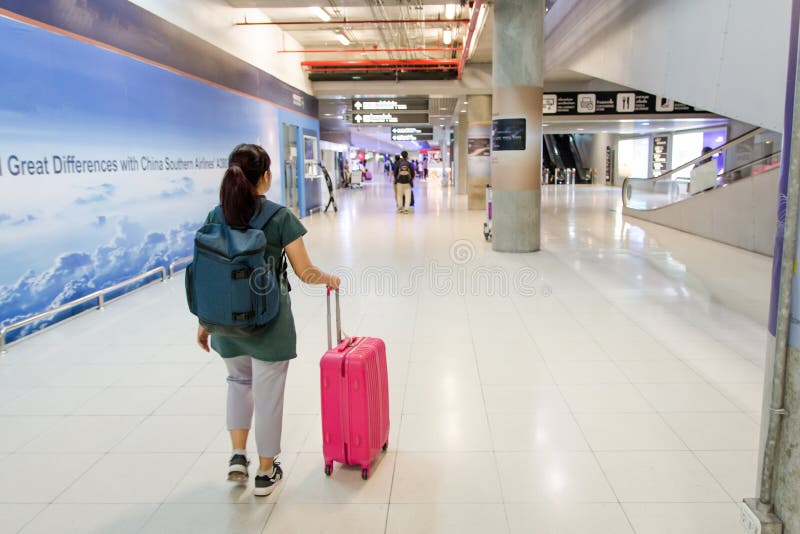 Travel concept. Woman carries your luggage at the suvarnabhumi a royalty free stock photo Travel concept. Woman carries your luggage at the suvarnabhumi a royalty free stock photo