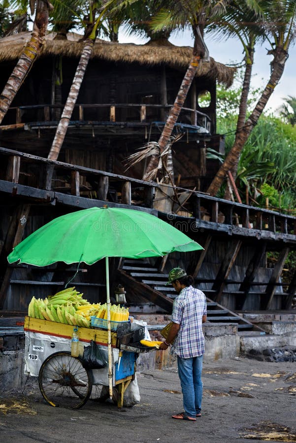 Travel destination. A man with his corn cob, selling grilled corn. Canggu, Bali, Indonesia 02 October 2016. royalty free stock photography Travel destination. A man with his corn cob, selling grilled corn. Canggu, Bali, Indonesia 02 October 2016. royalty free stock photography