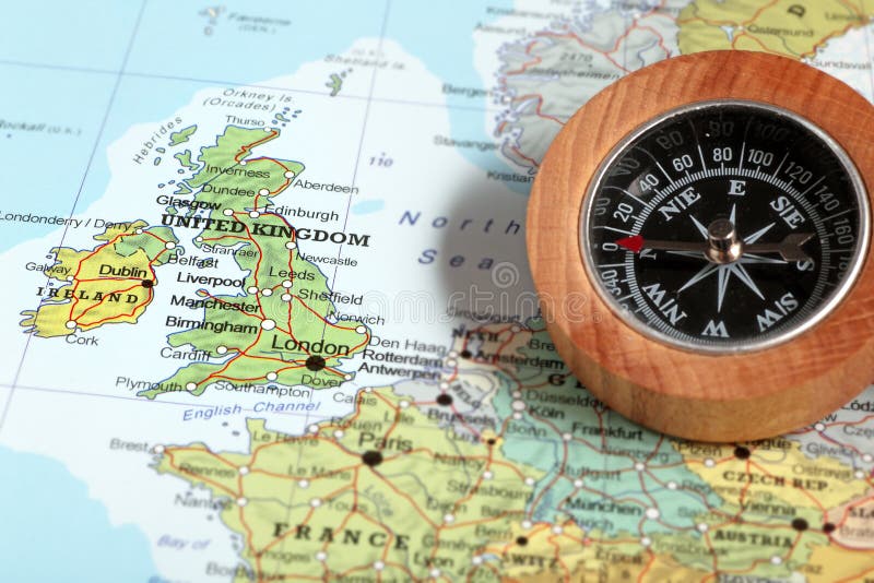 Compass on a map pointing at United Kingdom and Ireland, planning a travel destination. Compass on a map pointing at United Kingdom and Ireland, planning a travel destination