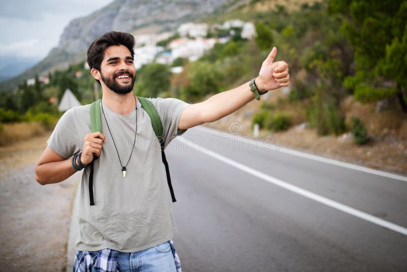 Travel man backpacking hitchhiking on road trip hitching a ride from car stock photos Travel man backpacking hitchhiking on road trip hitching a ride from car stock photos