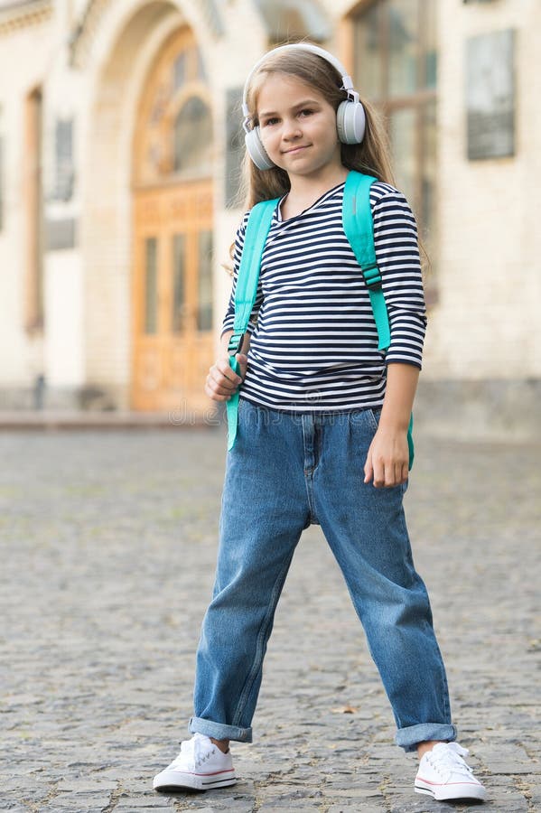 Travel means learning. Little kid carry travel bag listening to music outdoors. Educational school trip. Tourism