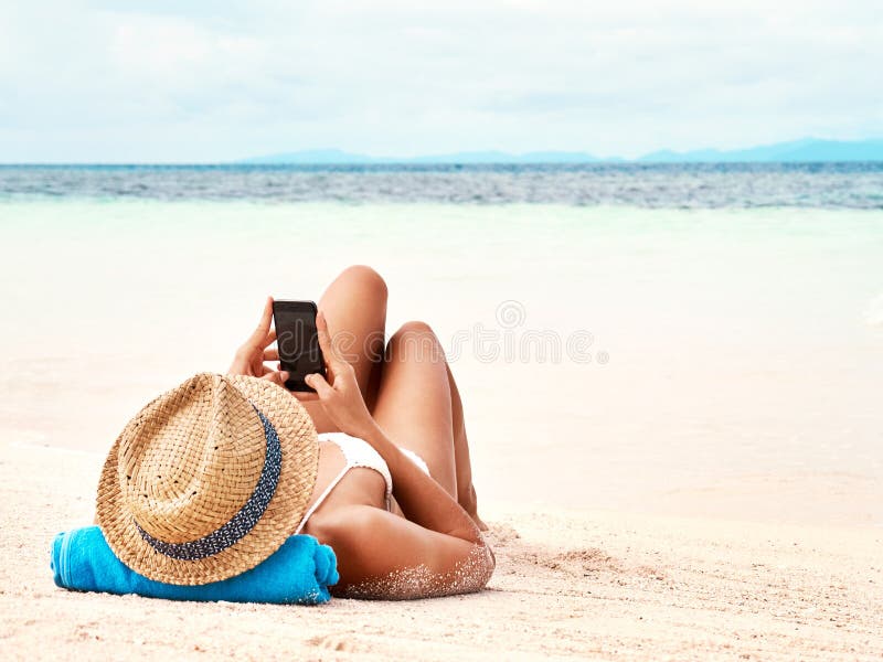 Travel, phone and woman relaxing on the beach scrolling on social media or mobile app on holiday. Rest, tropical and