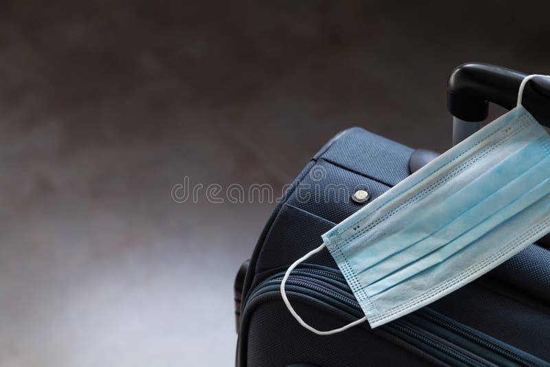 Travel suitcase and medical mask. The ban on travel during the epidemic of the coronavirus and the introduction of quarantine. Concept stock photos Travel suitcase and medical mask. The ban on travel during the epidemic of the coronavirus and the introduction of quarantine. Concept stock photos
