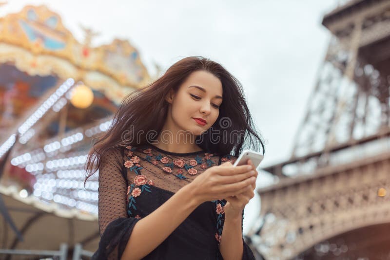 Travel woman using smartphone near the Eiffel tower and carousel, Paris. stock images Travel woman using smartphone near the Eiffel tower and carousel, Paris. stock images