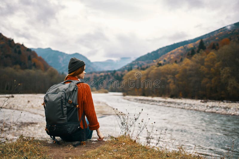 A Traveler in a Jacket Jeans and Boots Climbs the Mountains in Nature