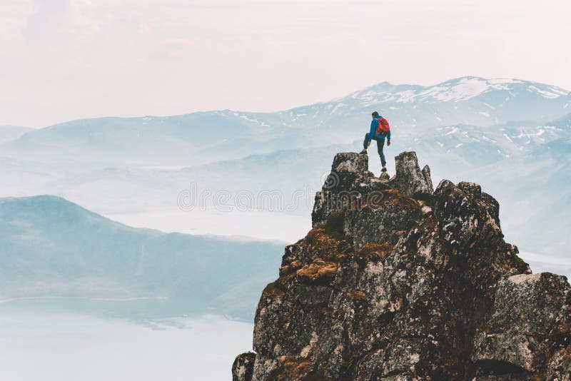 Traveler man climbing on mountain top adventure travel extreme healthy lifestyle vacations hiking outdoor success achievement brave hiker on the edge