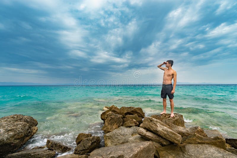 Traveler Shirtless Standing on the Rocks Near the Sea Looking Far Away ...