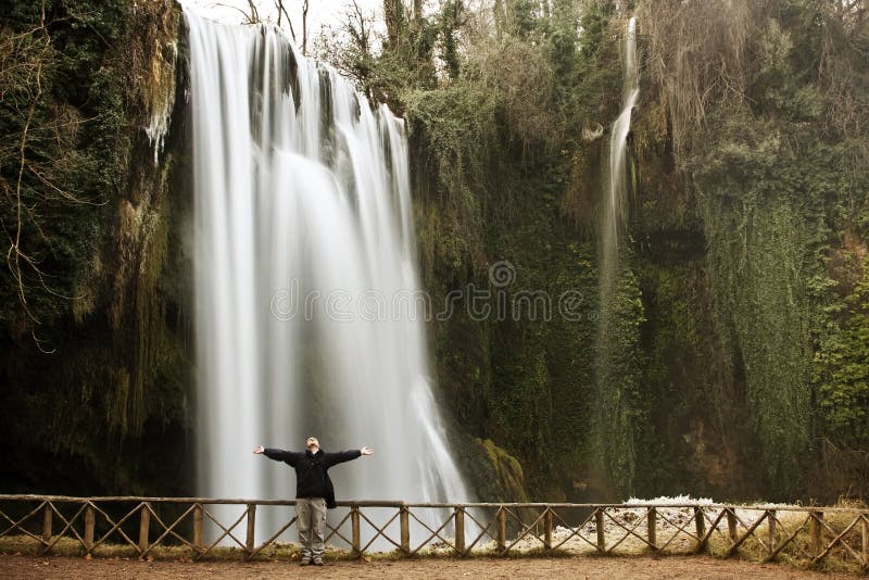 Traveler under waterfall