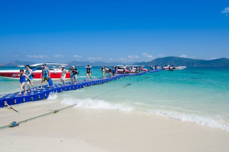 Traveler walking on the plastic box bridge to the coral island