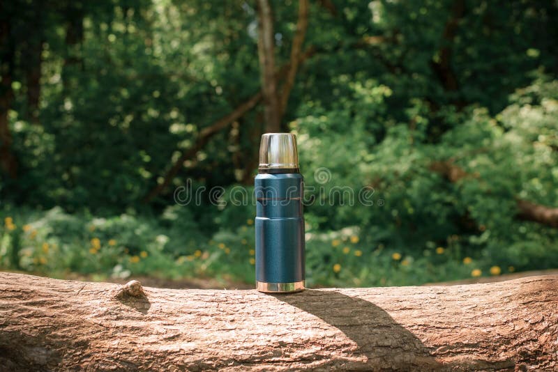 https://thumbs.dreamstime.com/b/traveling-blue-thermos-log-forest-outdoor-camping-reusable-flask-concept-hiking-nature-221189071.jpg