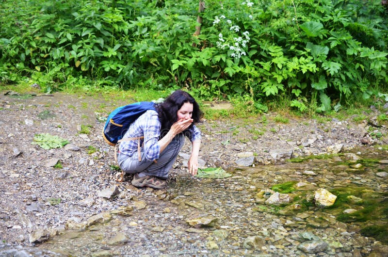 Traveling woman washing face with water from stream stock image Traveling woman washing face with water from stream stock image
