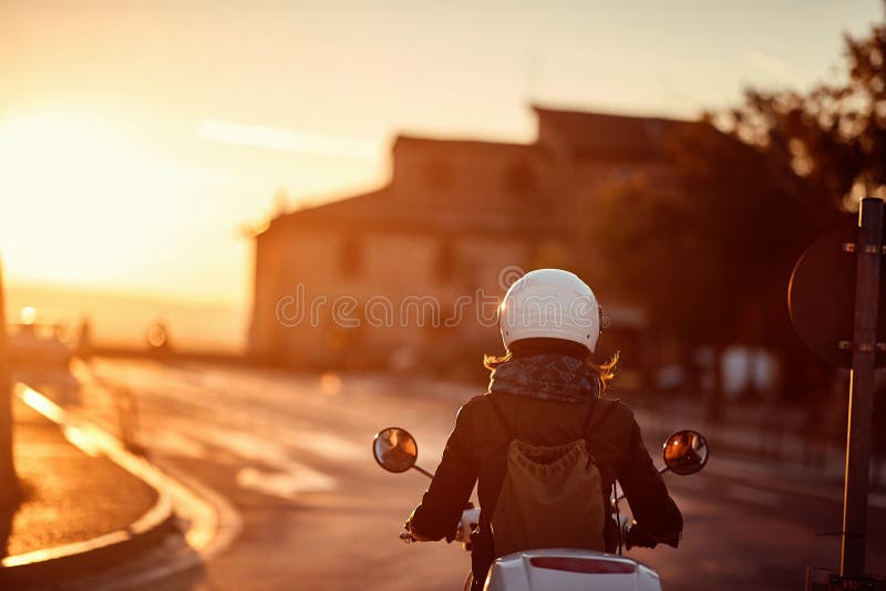 Travels by scooter. girl riding motor scooter on road