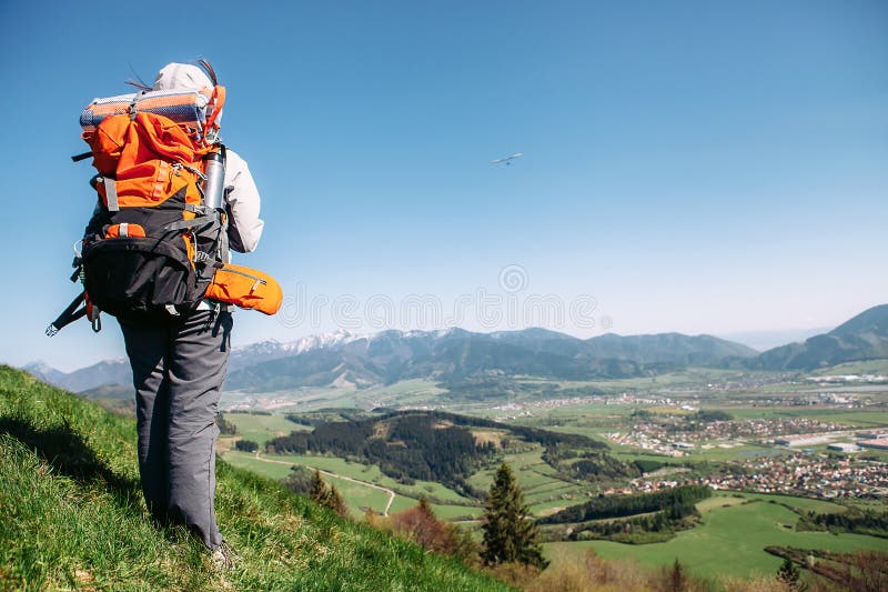 Traweler de femme avec le séjour de sac à dos sur le dessus de la colline Image active de concept de personnes images libres de droits Traweler de femme avec le séjour de sac à dos sur le dessus de la colline Image active de concept de personnes images libres de droits