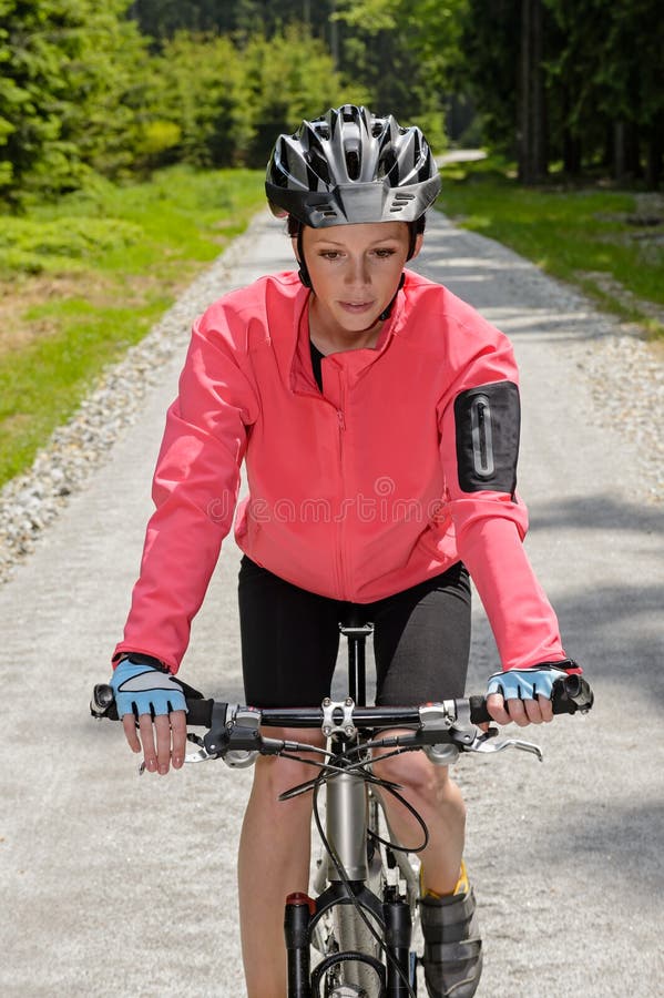 Trayectoria soleada del campo de la bici de montaña del montar a caballo de la mujer fotos de archivo libres de regalías Trayectoria soleada del campo de la bici de montaña del montar a caballo de la mujer fotos de archivo libres de regalías