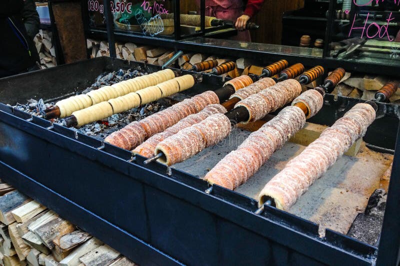 Trdelnik, traditioneel die dessert in een open brand houten staak wordt gebakken in Kerstmismarkt van Praag royalty-vrije stock afbeeldingen Trdelnik, traditioneel die dessert in een open brand houten staak wordt gebakken in Kerstmismarkt van Praag royalty-vrije stock afbeeldingen