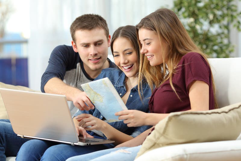 Tre amici che progettano viaggio a casa fotografia stock Tre amici che progettano viaggio a casa fotografia stock