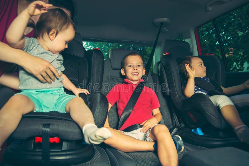 Tre bambini nel sedile di sicurezza dell'automobile immagine stock libera da diritti Tre bambini nel sedile di sicurezza dell'automobile immagine stock libera da diritti