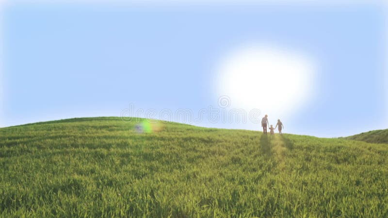 Tre bambini stanno scalando sulla collina verde Giorno di sorgente pieno di sole