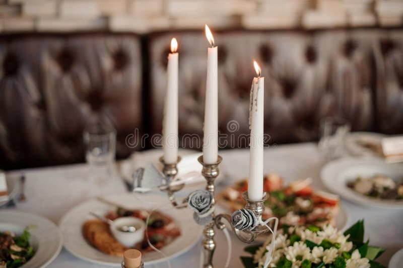Tre candele nel supporto di candela elegante che decora una tavola fotografie stock libere da diritti Tre candele nel supporto di candela elegante che decora una tavola fotografie stock libere da diritti