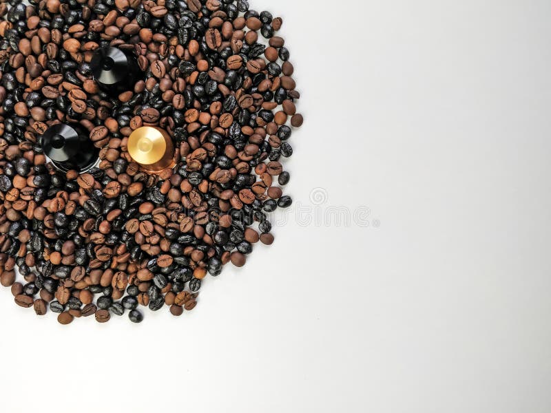Tre capsule del caffè circondate dai chicchi di caffè con spazio Vista superiore immagini stock libere da diritti Tre capsule del caffè circondate dai chicchi di caffè con spazio Vista superiore immagini stock libere da diritti