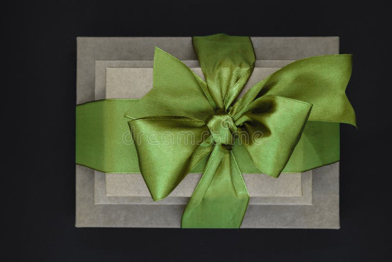 Tre contenitori di regalo marroni del cartone hanno impacchettato con il nastro verde isolato su fondo e sulla vista neri da sopr fotografie stock libere da diritti Tre contenitori di regalo marroni del cartone hanno impacchettato con il nastro verde isolato su fondo e sulla vista neri da sopr fotografie stock libere da diritti