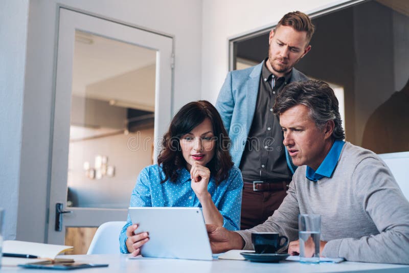 Tre coworkers som tillsammans använder en digital minnestavla i ett kontor arkivfoton Tre coworkers som tillsammans använder en digital minnestavla i ett kontor arkivfoton