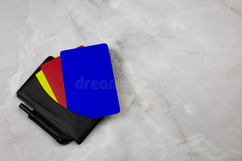 Three football cards in notebook for the chest pocket of football referee lie on white table. Three football cards in notebook for the chest pocket of football referee lie on white table