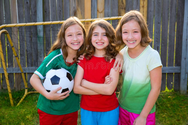 Tre giocatori del vincitore di calcio di calcio degli amici di ragazze della sorella immagini stock Tre giocatori del vincitore di calcio di calcio degli amici di ragazze della sorella immagini stock