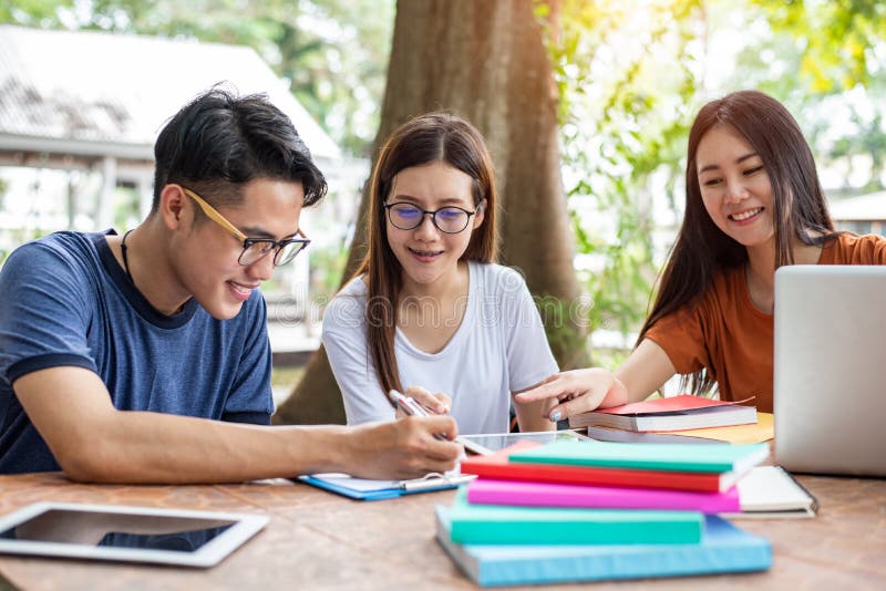 Tre giovani studenti asiatici della citt? universitaria godono insieme dei libri di lettura e di ripetizioni Concetto di istruzio fotografia stock libera da diritti Tre giovani studenti asiatici della citt? universitaria godono insieme dei libri di lettura e di ripetizioni Concetto di istruzio fotografia stock libera da diritti