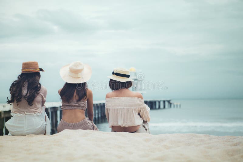 Tre kvinnor med halmhatt pÃ¥ semesterstranden