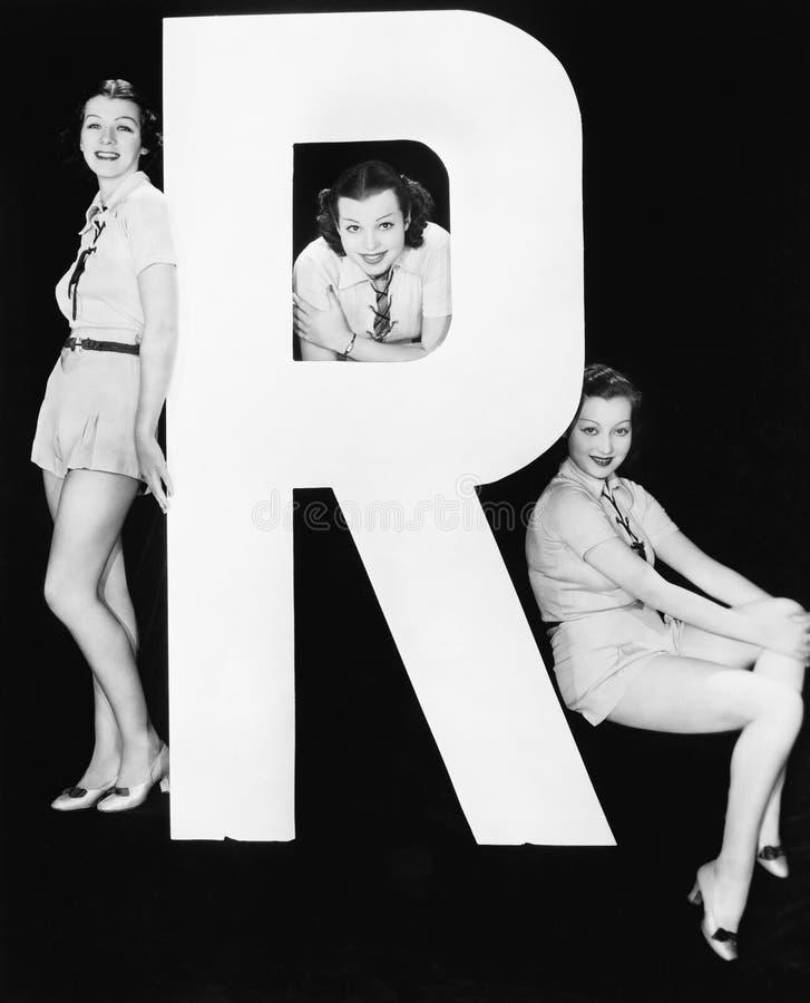 Tre kvinnor som poserar med enorm bokstav R (alla visade personer inte är längre uppehälle, och inget gods finns Leverantörgarant