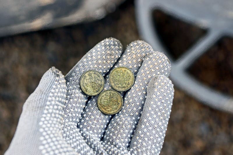 Tre lilla silvermynt på ett öppet gömma i handflatan i en grå handske royaltyfria foton Tre lilla silvermynt på ett öppet gömma i handflatan i en grå handske royaltyfria foton