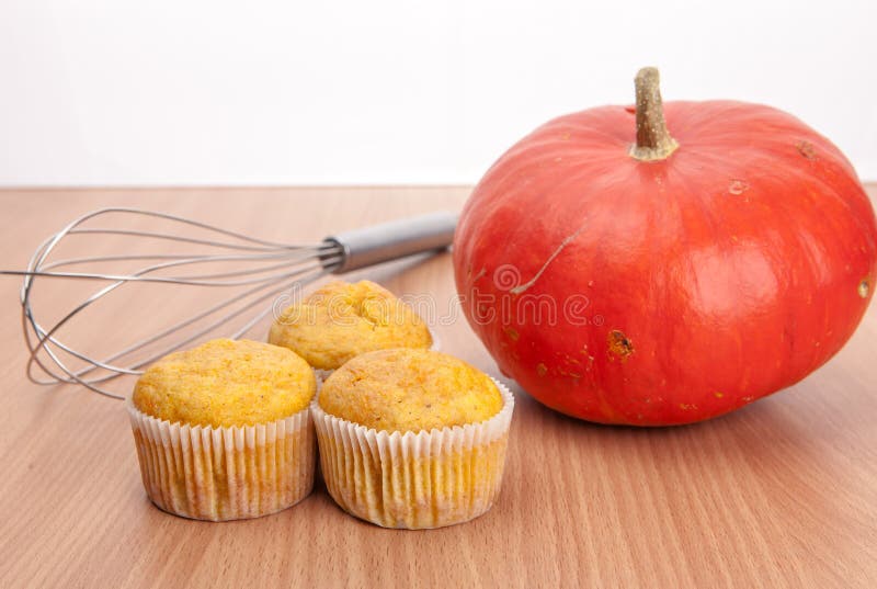 Tre muffin och pumpa på den wood texturtabellen arkivfoton Tre muffin och pumpa på den wood texturtabellen arkivfoton